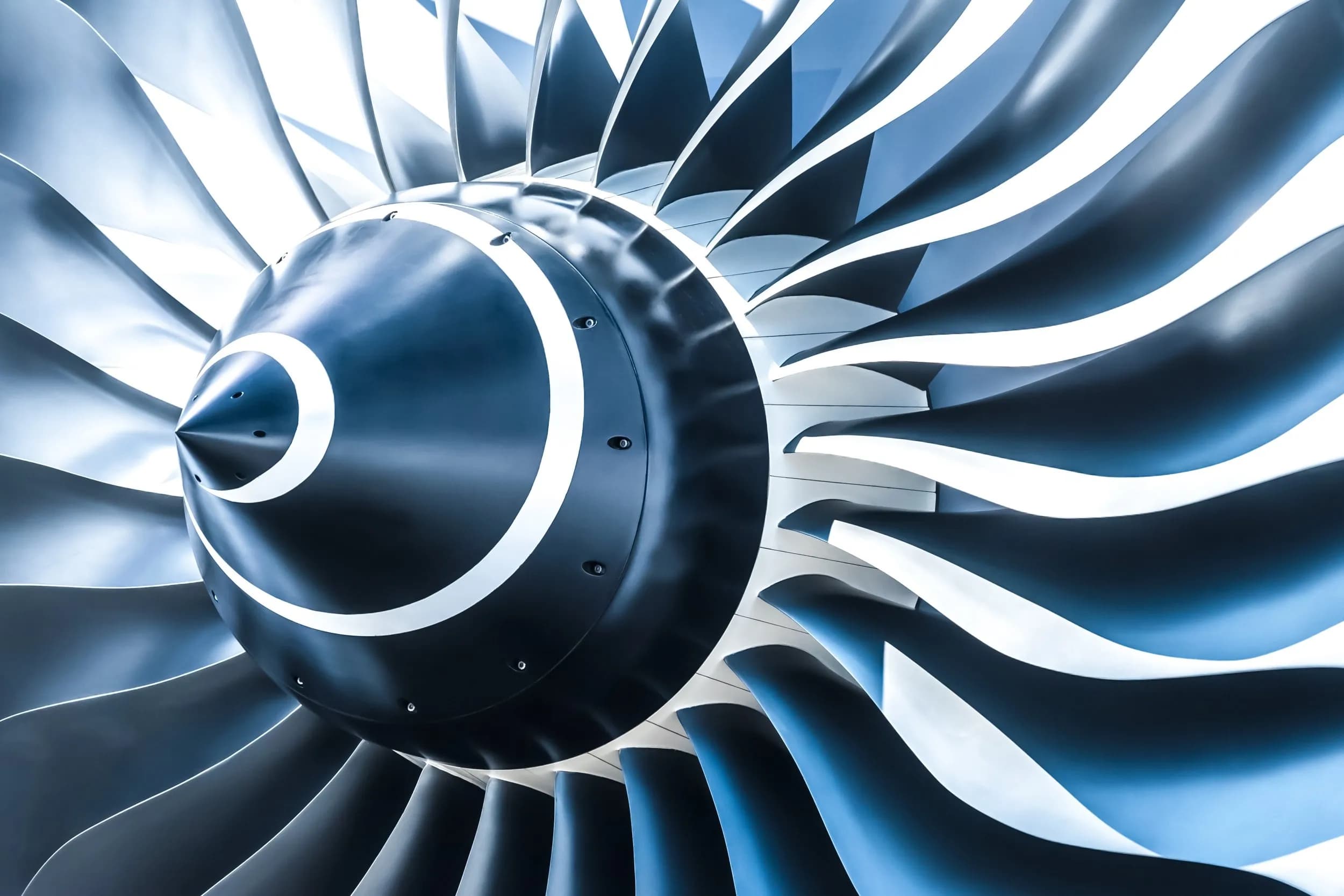 Detailed close-up of a high-precision jet engine intake turbine fan in metallic blue and silver tones.