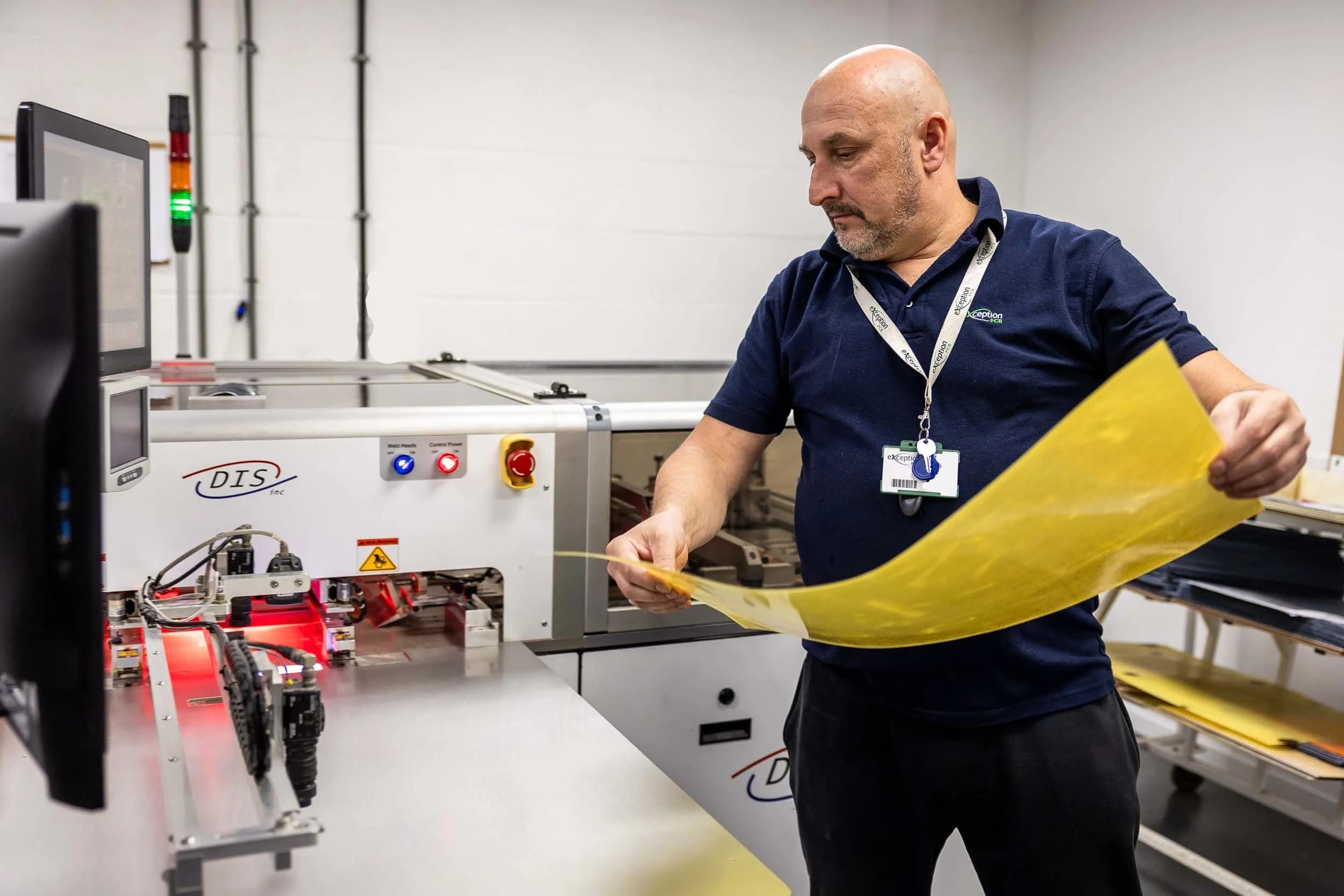 Exception PCB operator preparing a yellow translucent prepreg layer sheet for a multilayer bonding process.