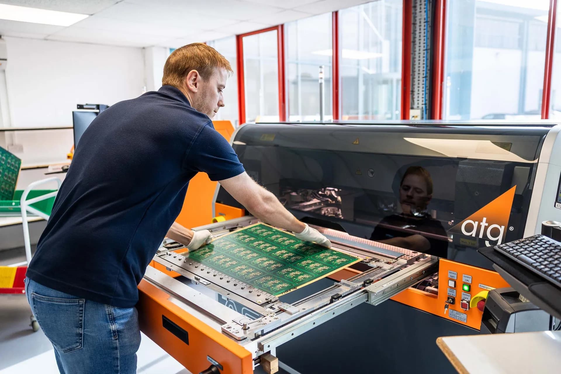 Exception PCB operator loading a PCB panel into an atg flying probe electrical test system at the Tewkesbury manufacturing facility