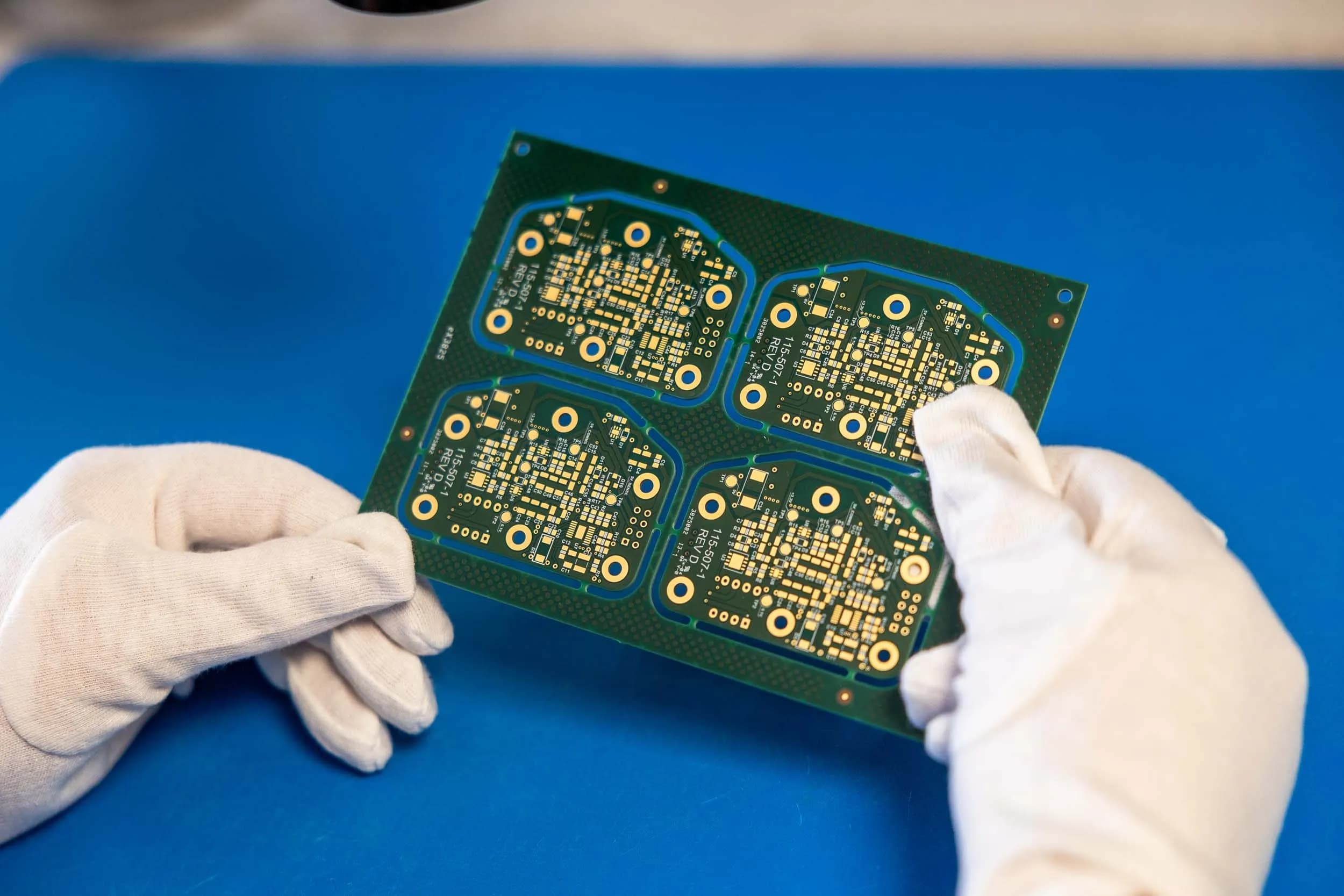 Close-up of a printed circuit board being manually inspected by an Exception PCB engineer.