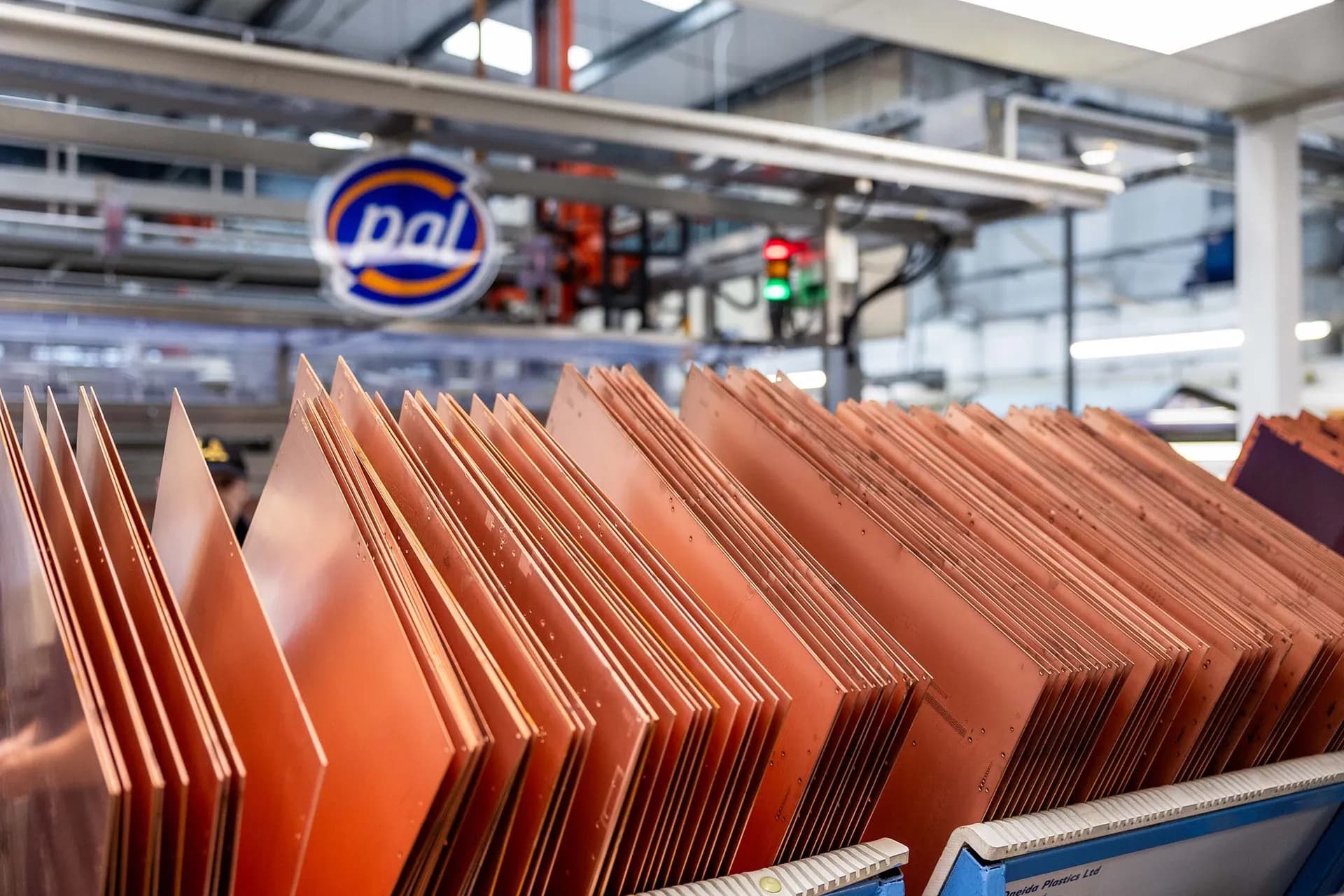 Close-up of a large rack of copper printed circuit board panels awaiting processing, under PAL branding.