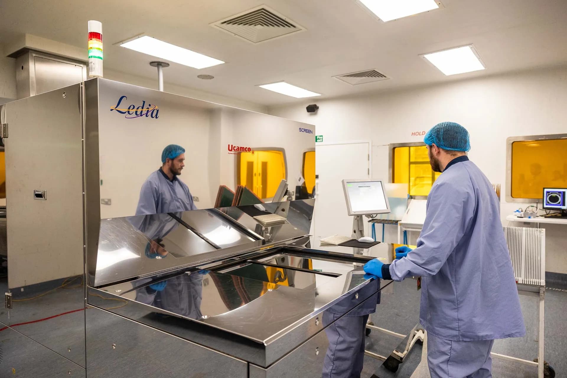 Exception PCB operator loading a panel into the Ucamco Ledia direct imager in the cleanroom imaging area at the Tewkesbury manufacturing facility